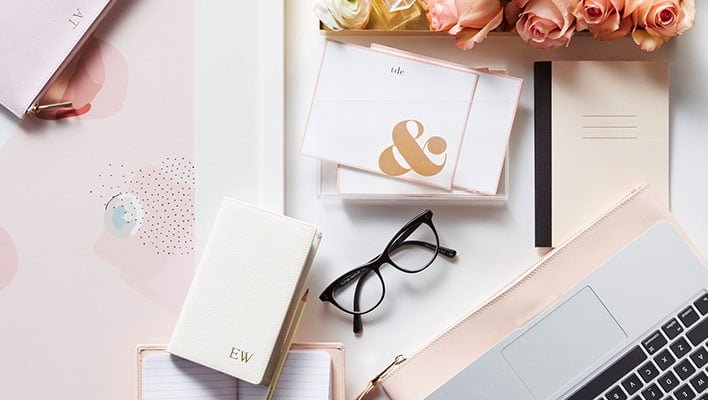 computer with notebook in pink background