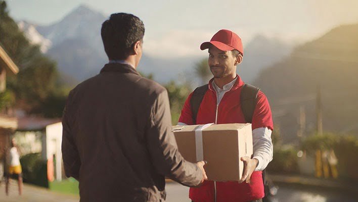 About us :man receiving parcel from delivery boy